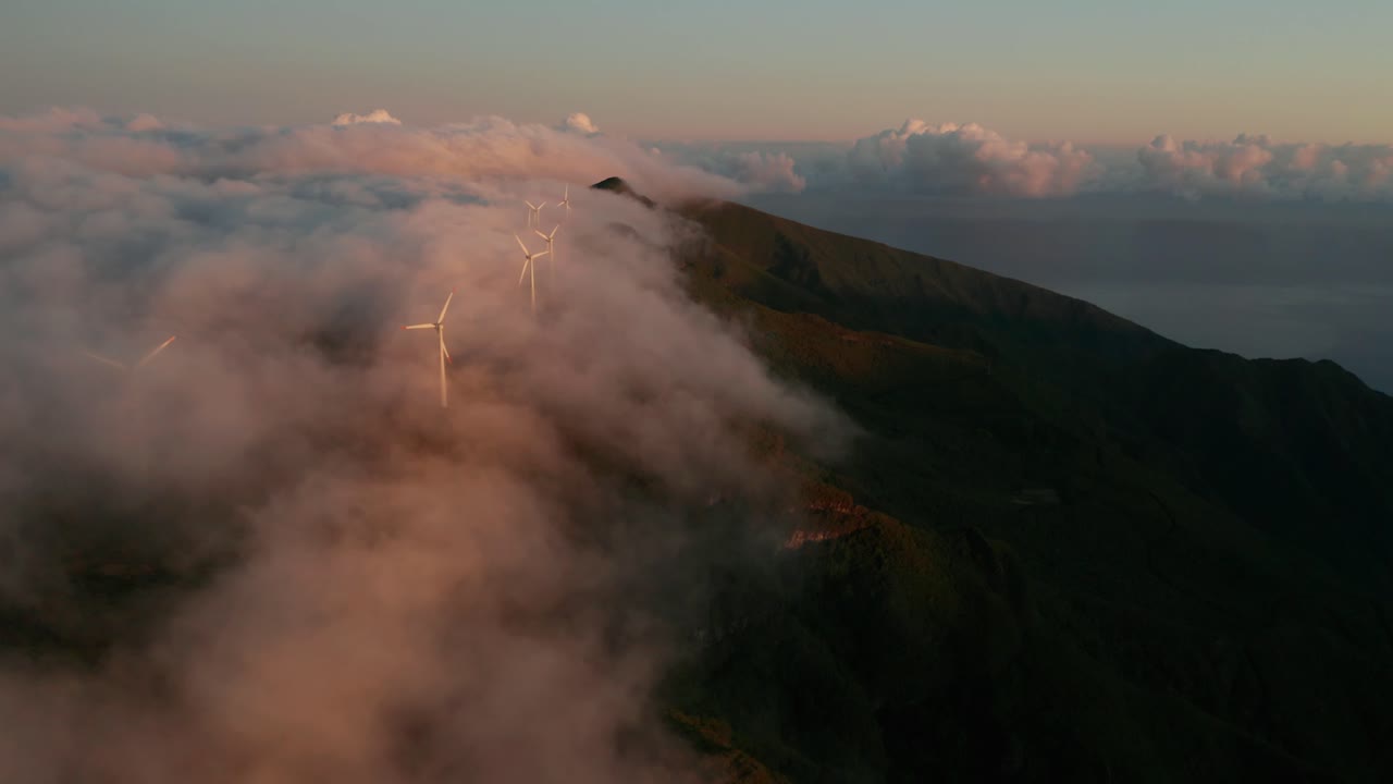 increíble niebla mágica fluye sobre montañas con turbinas eólicas girando aspas