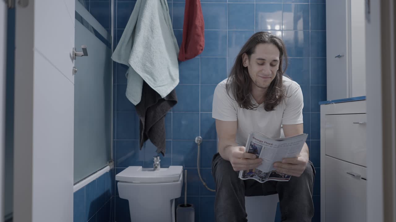 Man Reading in Bathroom