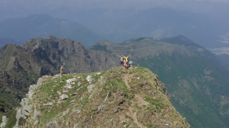 Gruppo di escursionisti in cima alla montagna, ripresa con drone. Vista aerea di escursionisti in cima alla montagna che festeggiano la salita.