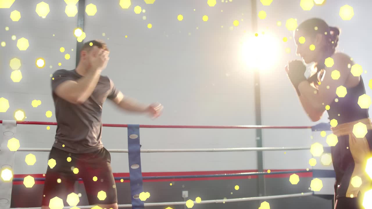 Male trainer throwing jabs, female boxer parrying in boxing drill, yellow overlay and lens flare