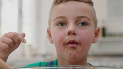 happy little boy tasting delicious chocolate treats in kitchen enjoying homemade sweets having fun on weekend