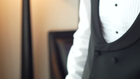 the groom putting on the watch in the room