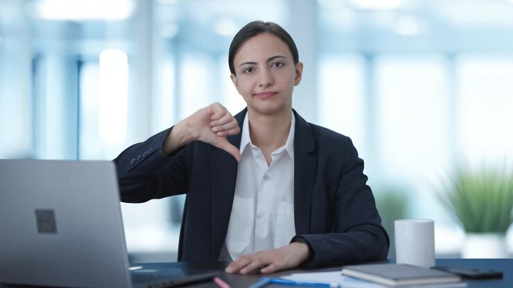 mujer de negocios india molesta mostrando los pulgares hacia abajo