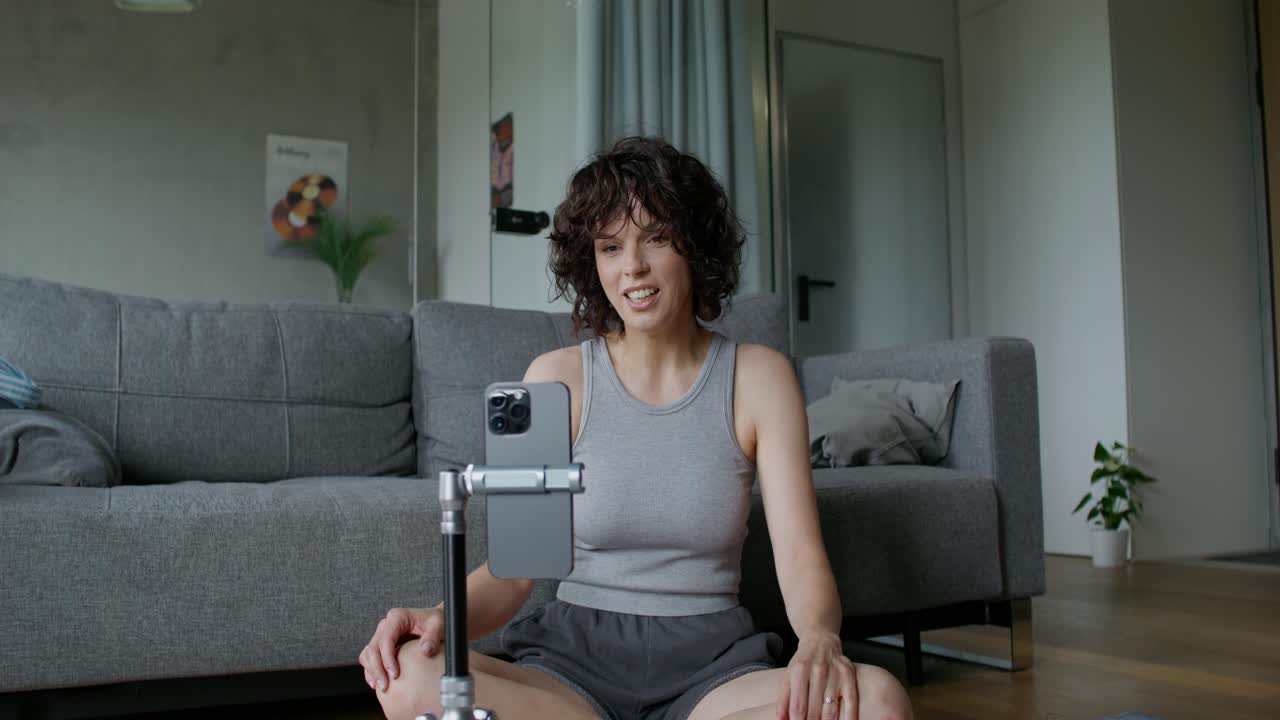 mujer dando un tutorial de video en línea en una sala de estar
