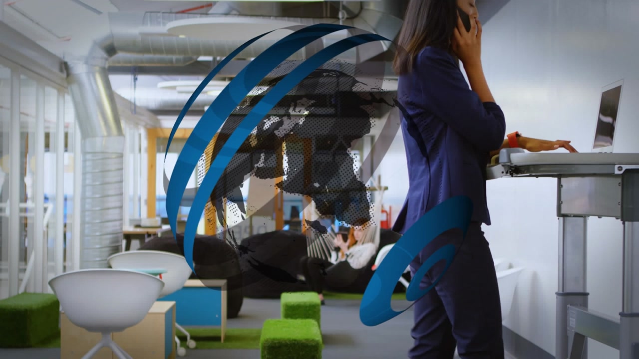 An executive is talking on the phone while exercising on a treadmill in an office
