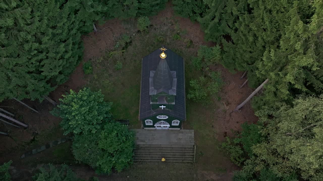 Drone shot of a countryside chapel surrounded by rolling greenery