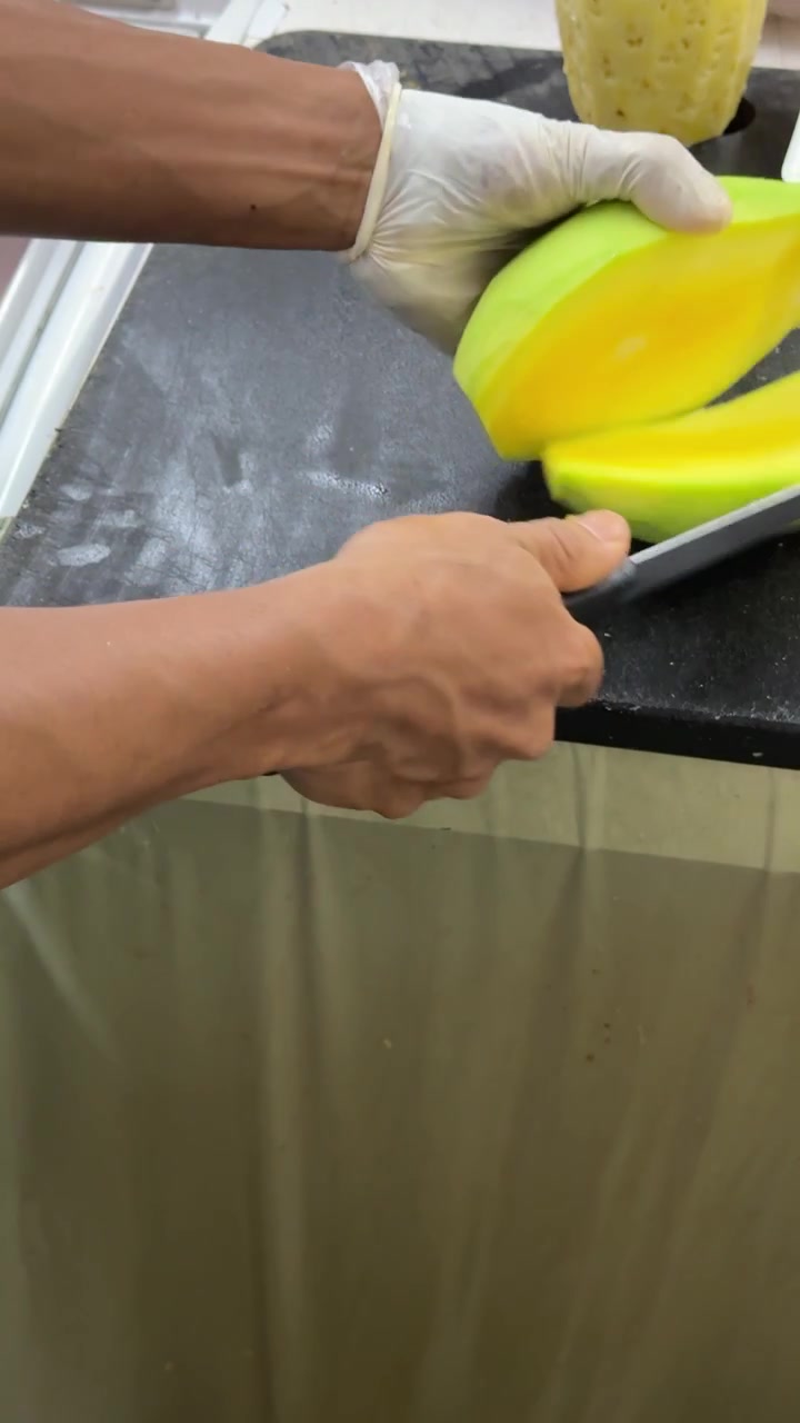 Chef Slicing Fresh Green Mango on Kitchen Counter