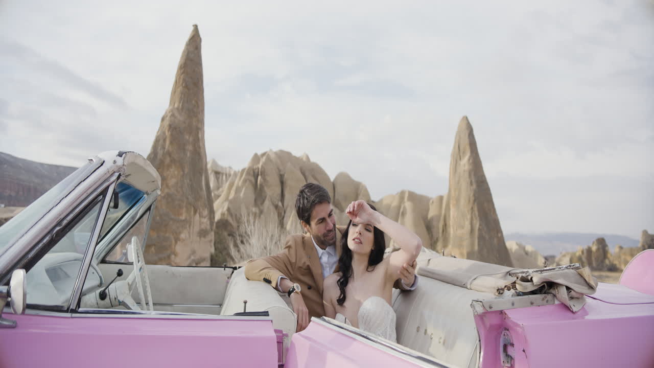 Romantiskt par i en vintage rosa cabriolet i Kappadokien