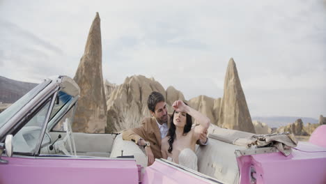 romantic couple in vintage pink convertible in cappadocia