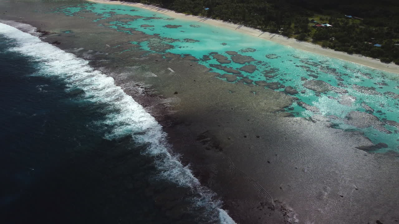 Ocean waves break on coral reef off Cengeite or Yejele Beach. Maré Island. Aerial