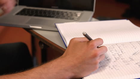 estudiante tomando notas en la conferencia