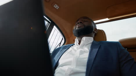 Portrait-of-puzzled-african-american-man-getting-bad-news-at-luxury-car.