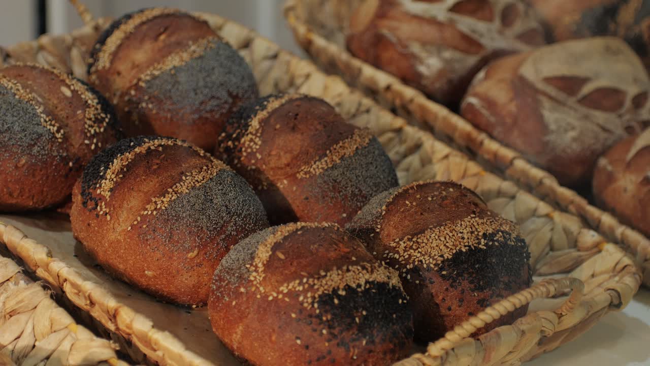 Fresh artesian bread on bakery shop close-up. Bread with black poppy garnish on top and white flour on top. Artisan bread is making by skill bakers using natural and high-quality ingredients. Food with health and flavour benefits.