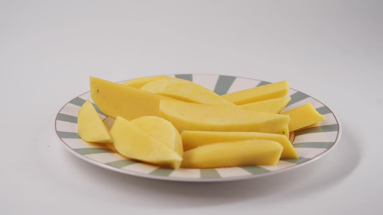 Mano che prende una patata cruda affettata da un piatto