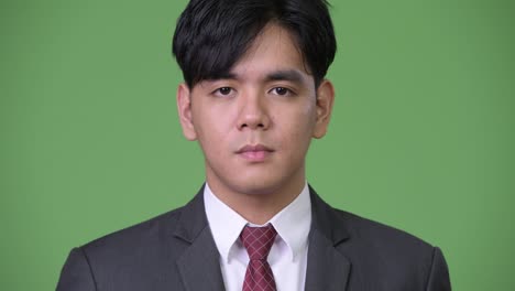 joven empresario asiático apuesto cubriendo los ojos como tres monos sabios concepto