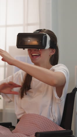 cheerful woman in wheelchair laughs with friend playing fun video game. person with disability in vr goggles enjoys virtual reality moving hands closeup