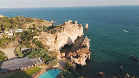 aerial perspective showcasing alvor cliffs, coastline, and lush surroundings in portugal. push forward shot