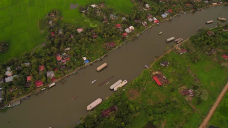 Aerial-view-of-several-boats-cruising-tropical-river-in-Kumarakom,-Kerala