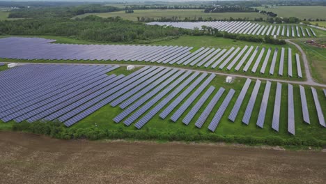 Solar-Power-Station-Panels-In-Green-Field---aerial-shot