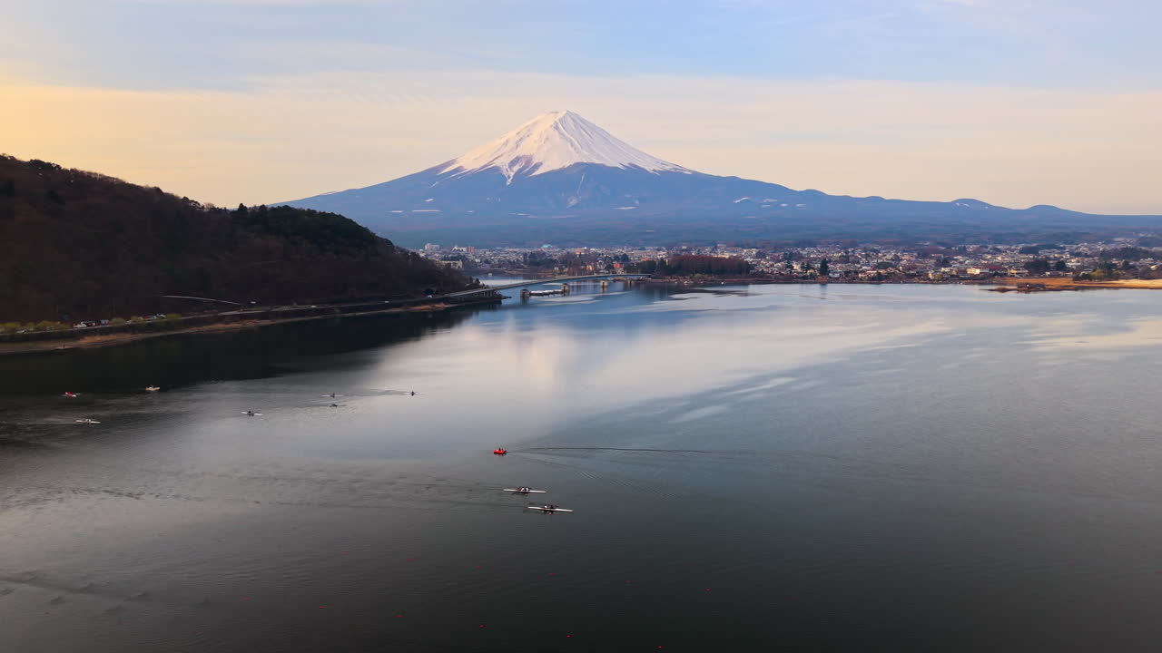 Aerial drone view of boats moving on Lake Kawaguchiko near the Fujikawaguchiko town, Japan at sunset