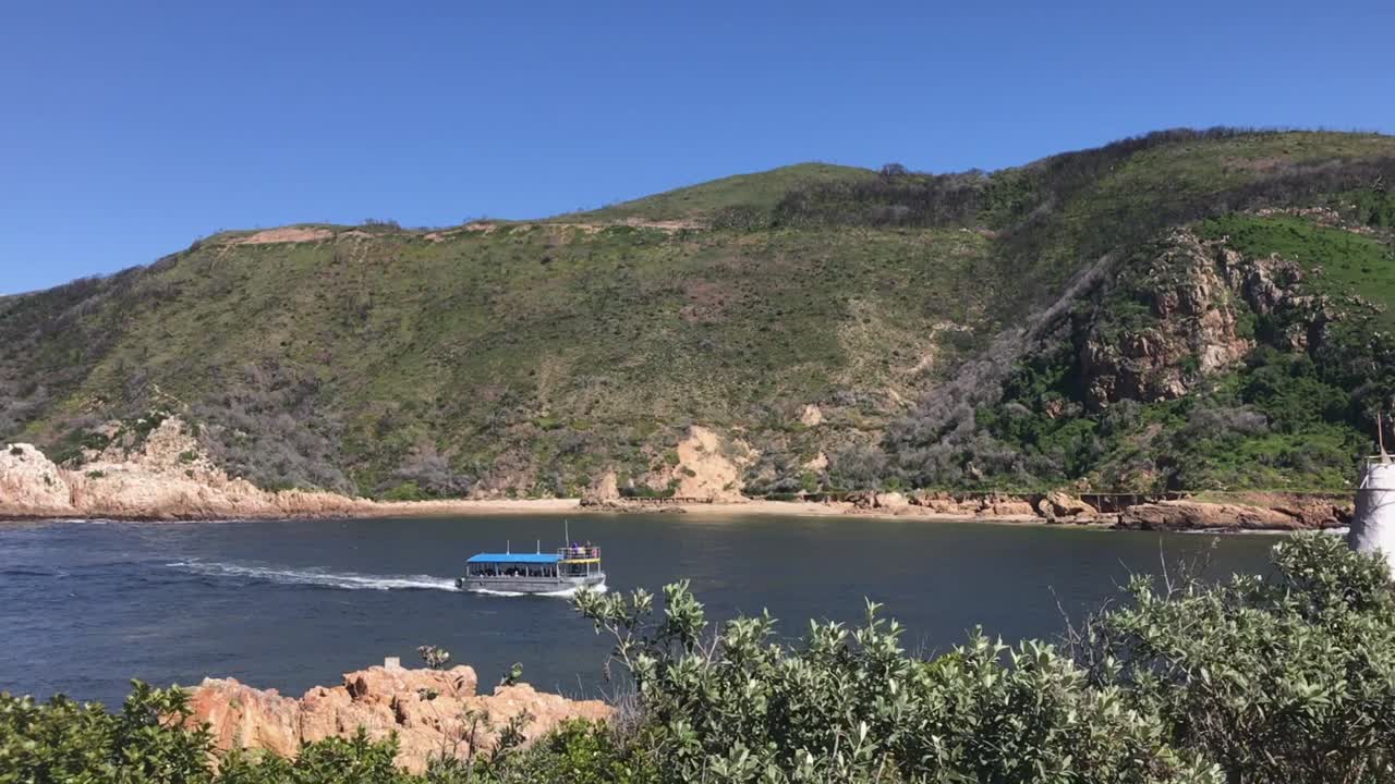 아프리카의 가든 루트에 있는 나이스나 헤드에서 적재된 투어 보트가 돌아옵니다.