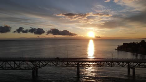 4k drone video of car driving on mackinac bridge in michigan at sunrise.