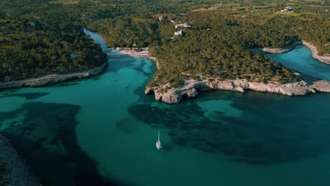 sailing yacht boat clear turquoise blue sea water in a remote natural bay, palma de mallorca island