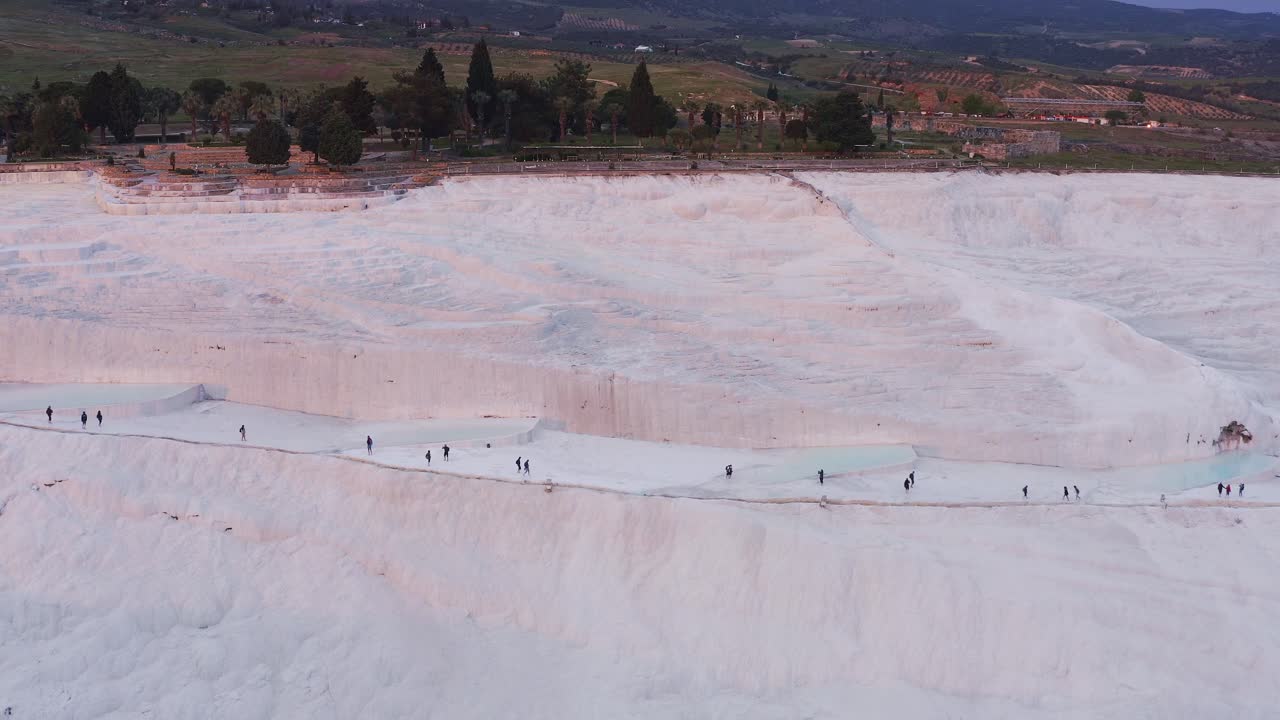 Drone of Tourists walk the travertine geothermal attraction Pamukkale