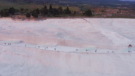 drone of tourists walk the travertine geothermal attraction pamukkale