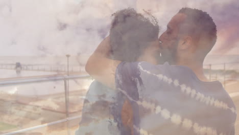 couple embracing with cloudy sky animation overlay on serene landscape background