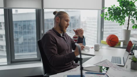 Focused-teacher-explaining-video-call-at-office-closeup.-Man-teaching-online