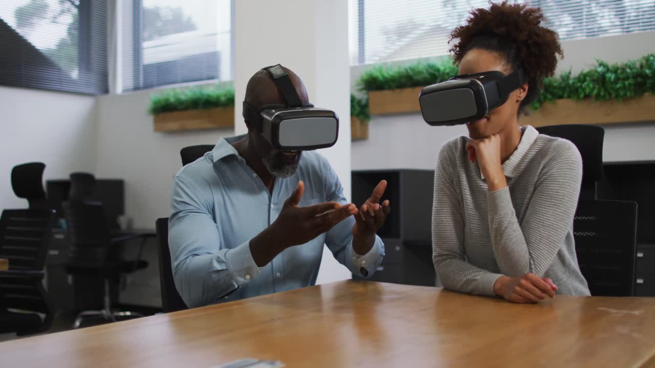 Diverse male and female business colleagues wearing vr headsets in office