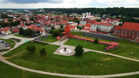tomada de un avión no tripulado del histórico castillo de ladrillo rojo de kaunas con bandera ucraniana en el casco antiguo de kaunas, lituania, alejándose