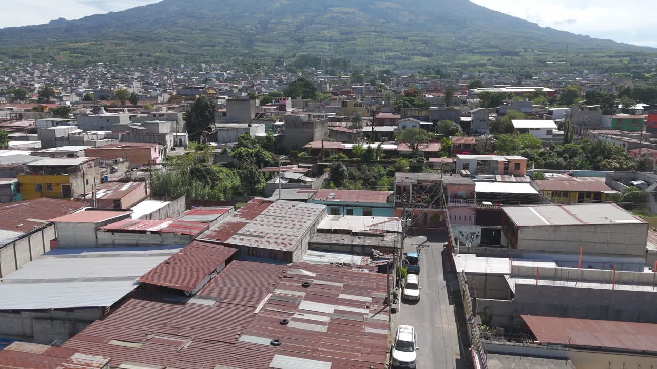 Vibrant city lies at the base of Volcan de Agua, surrounded by lush greenery and mountain slopes in Guatemala