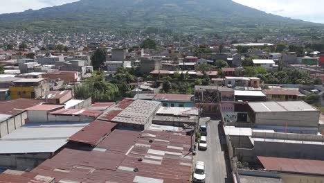 vibrant city lies at the base of volcan de agua, surrounded by lush greenery and mountain slopes in guatemala