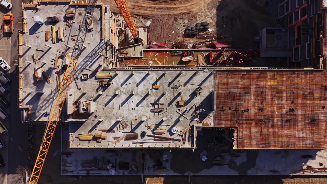 Aerial Top-Down View of a Busy Construction Site with Workers and Crane