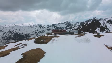 Wide-and-epic-4K-cinematic-panorama-circular-aerial-orbit-scenic-Zillertal-skiing-hiking-sports-Kristallhütte-Bergstation-cabin-near-Innsbruck-towards-the-snowy-glacier-mountain-tops-in-the-alps