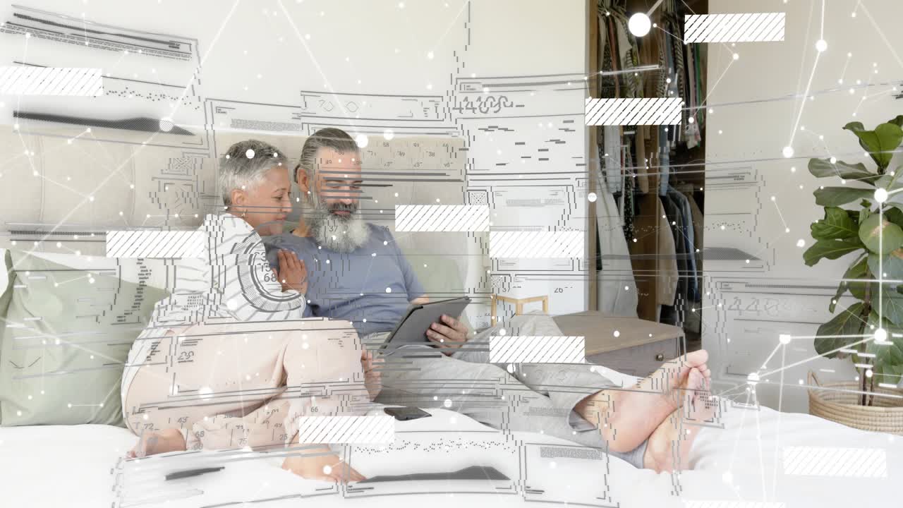 Man holding tablet and woman leaning on bed, tapping to start animated tech graphs sharing data