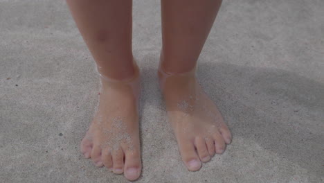 niñas pequeñas con pies en el mar poco profundo.