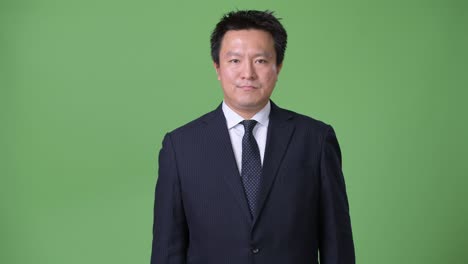 녹색 배경에 성숙한 일본 사업가