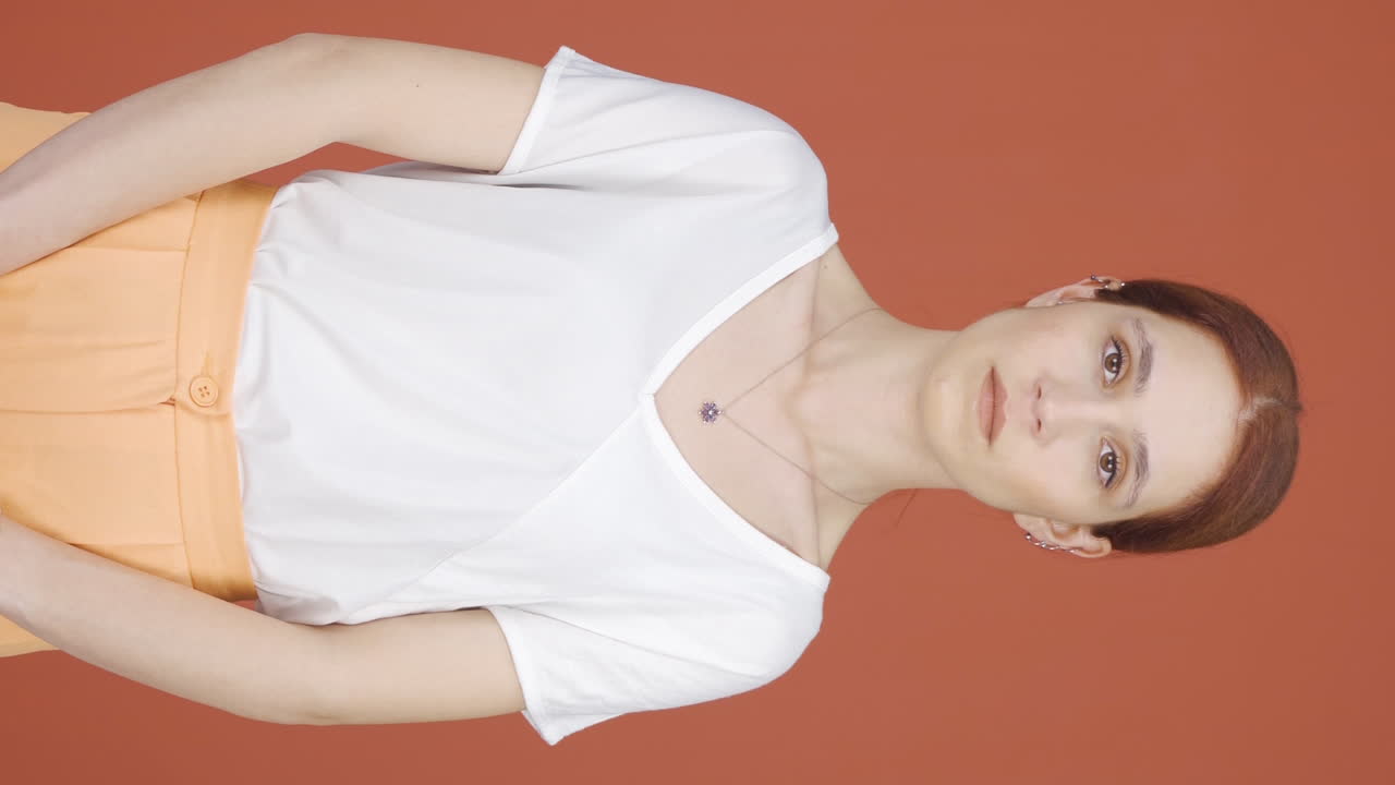 video vertical de una mujer mirando a la cámara con una expresión aburrida.