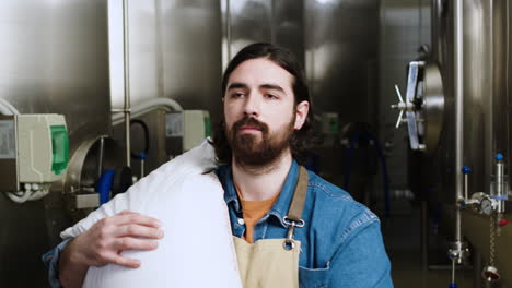 un homme portant un sac de malt