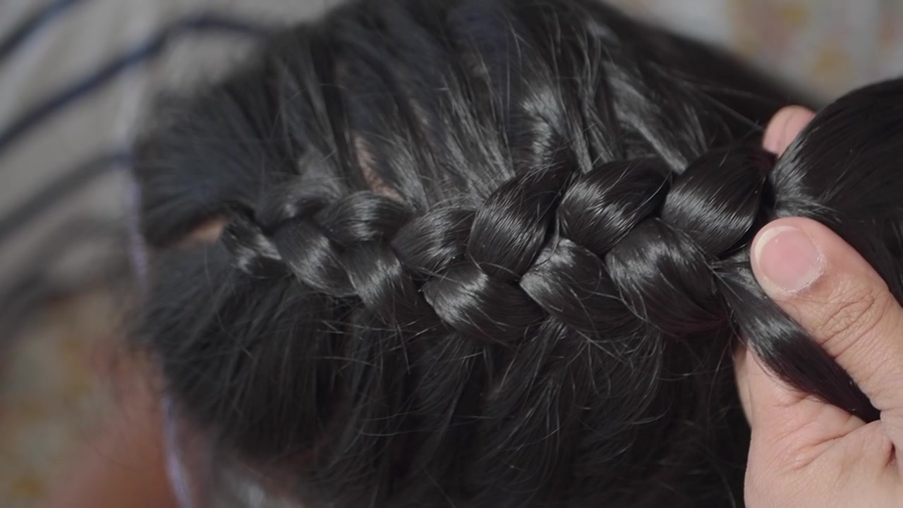 Primo piano di mani che intrecciano lunghi capelli scuri