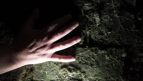 mano arrastrando hacia abajo la espeluznante vieja pared verde grunge en primer plano