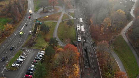 vista aérea del paso del tren cerca de una carretera muy transitada en un día de niebla, retroceso
