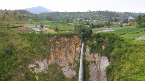 Vista-Aérea-De-La-Cascada-De-Sipiso-Piso-En-El-Norte-De-Sumatra,-Indonesia---Drone-Volando-Hacia-Arriba-Y-Lejos