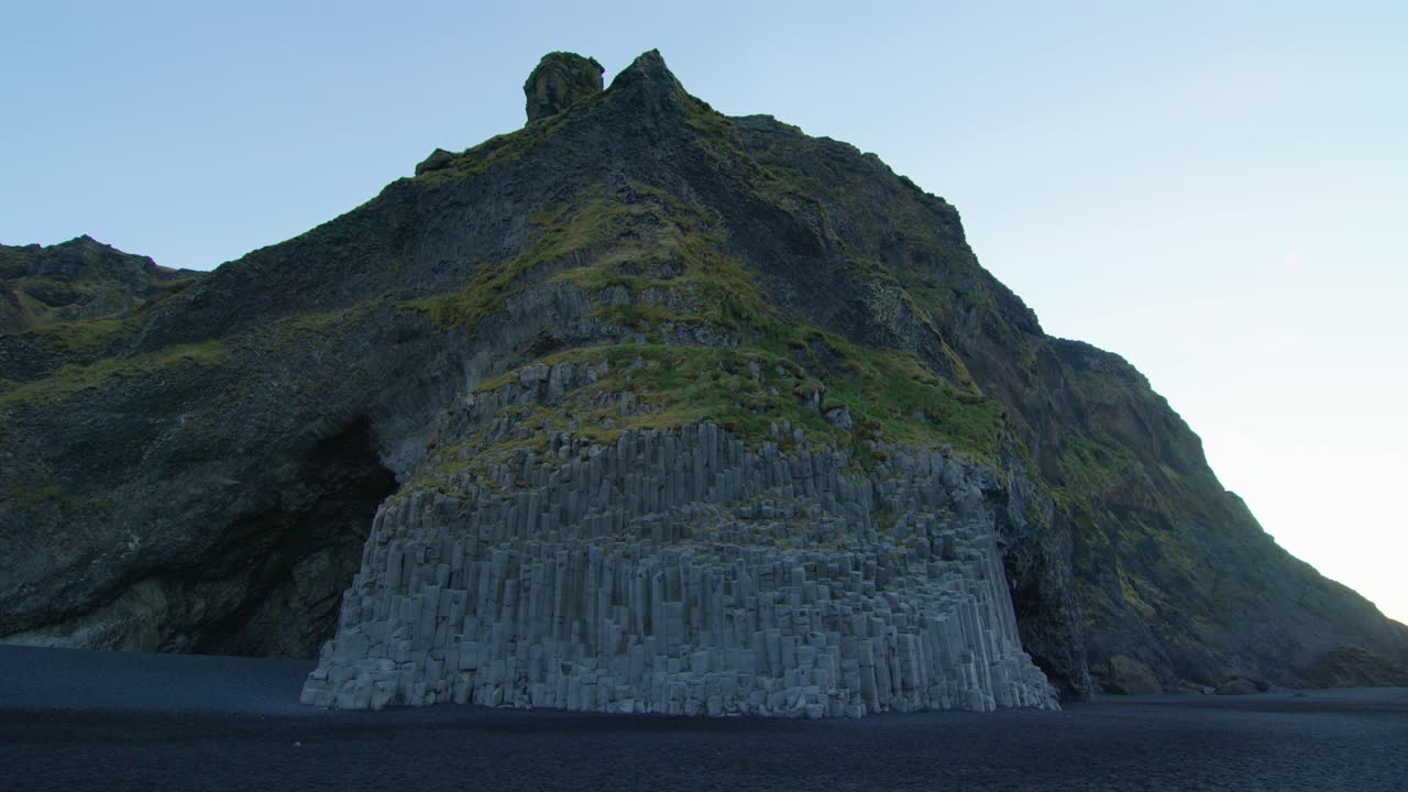 H&aacute;lsanefshellir Cave on green rocks at Black Sand Beach in Iceland in sunrise without tourists and people