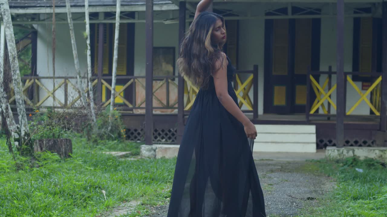 A black-dressed young girl wandering through a historical site.