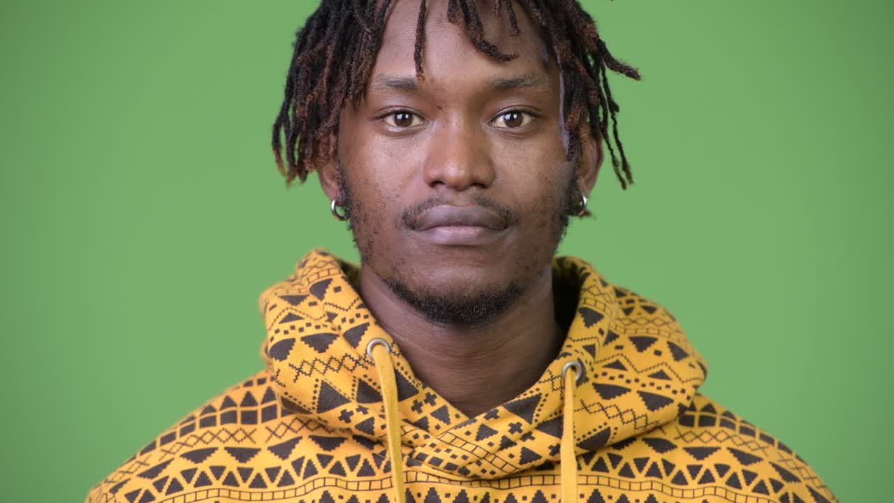 joven y guapo hombre africano contra un fondo verde