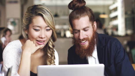 Young-couple-shopping-online-using-digital-tablet-computer-in-cafe